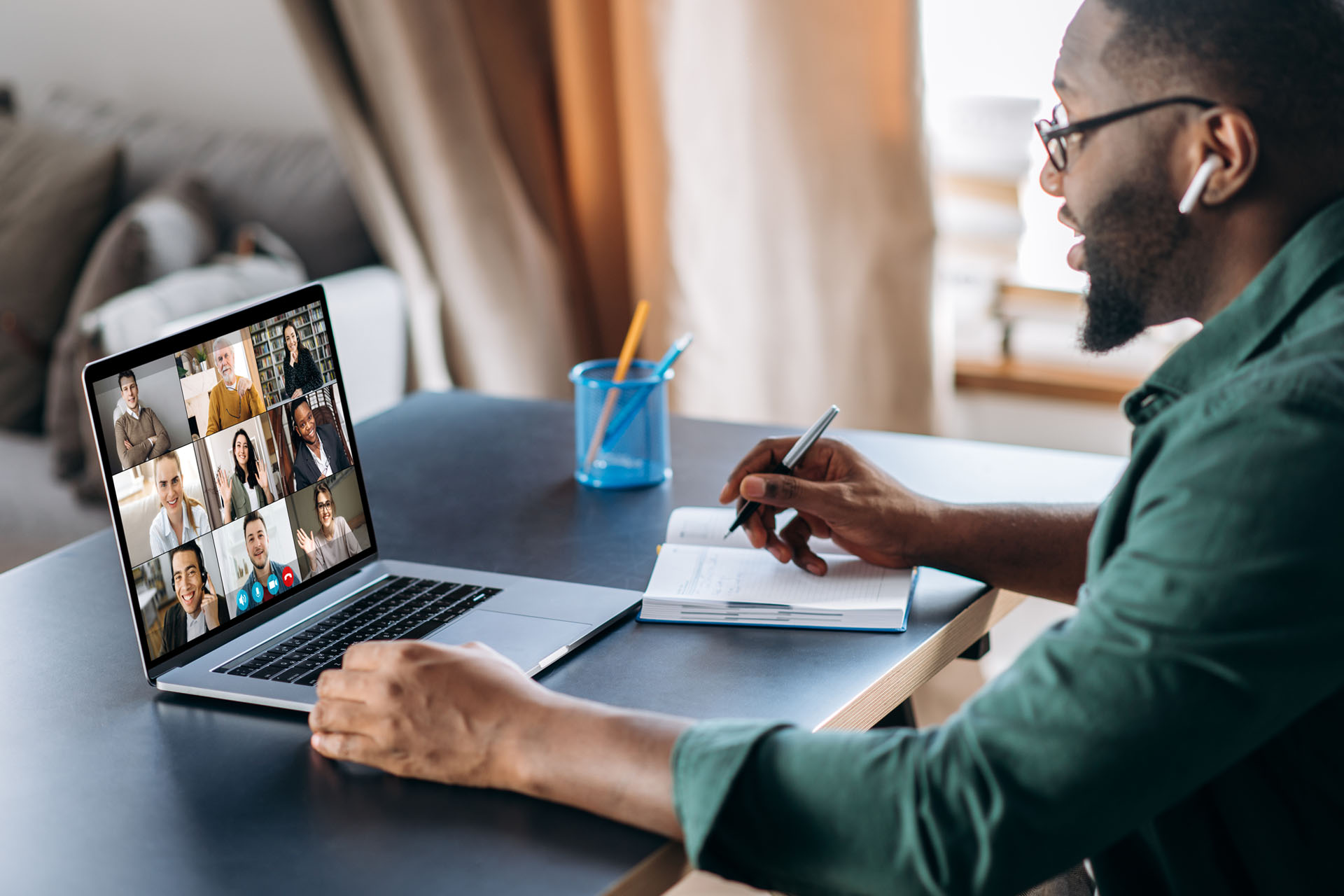 A man views a laptop at a virtual meeting